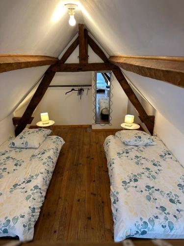 une chambre mansardée avec deux lits et une fenêtre dans l'établissement Maison au cœur de Villandry, à Villandry