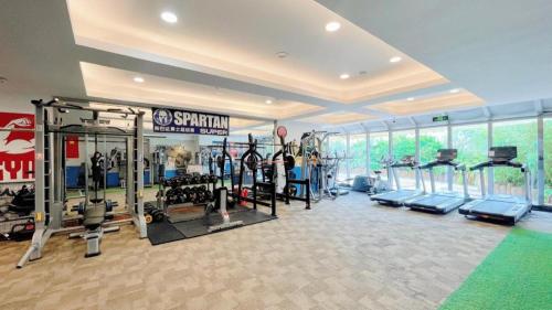 a gym with several tread machines in a room at Grand Soluxe Zhongyou Hotel Shenzhen in Shenzhen