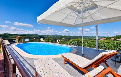 a swimming pool with two chairs and an umbrella at Awesome Home In Jalzabet With Kitchen in Jalžabet