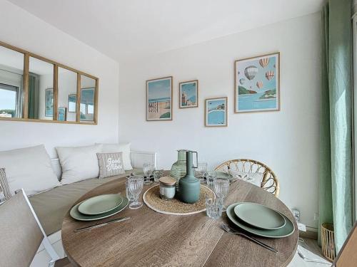 une table de salle à manger avec des assiettes et des verres dessus dans l'établissement 3385-Appartement 4 couchages à 400m de la plage, à Argelès-sur-Mer