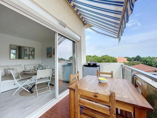 d'une terrasse avec une table et des chaises en bois sur un balcon. dans l'établissement 3385-Appartement 4 couchages à 400m de la plage, à Argelès-sur-Mer
