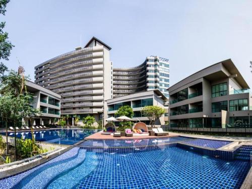 a swimming pool in front of some buildings at Green Valley Executive Serviced Residence in Chiang Mai