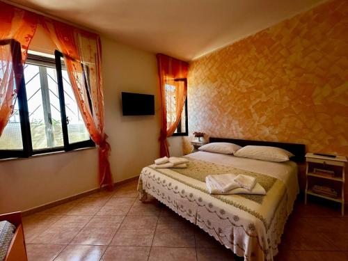 a bedroom with a bed in a room with windows at Casa via Appia Scauri - luminosa, grande a 250 m dal mare e dalla stazione ferroviaria in Scauri