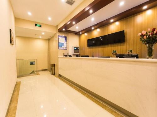 a hotel lobby with a reception counter and flowers at GreenTree Inn Suzhou Guanqian Street Leqiao Metro Station in Suzhou
