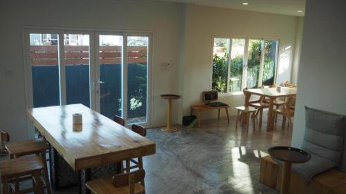 a living room with a table and a dining room at Maximize Brand New Hostel Udonthani in Udon Thani