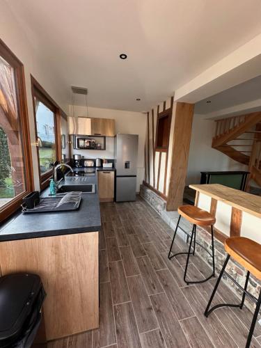 - une cuisine avec un comptoir et quelques chaises dans l'établissement Gîte Le Saint Vincent, à Saint-Vincent-Cramesnil