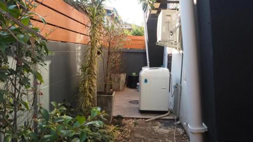 an outdoor patio with a heater and some plants at Maximize Brand New Hostel Udonthani in Udon Thani