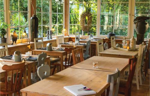 a restaurant with wooden tables and chairs and windows at Vakantiewoning 10 in Simpelveld
