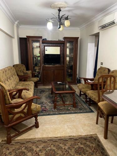 salon z krzesłami, stołem i telewizorem w obiekcie Alexandria Smouha Green Plaza Gateway,50 m from Green Plaza mall w Aleksandrii