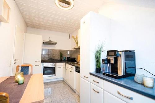 kuchnia z białymi szafkami i niebieskim blatem w obiekcie Willkommen im Apartment Lilly in Ladbergen direkt am Flughafen FMO w mieście Ladbergen