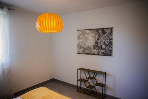 a room with a table and a lamp and a chair at OIQIA • Séquoia in LʼUnion
