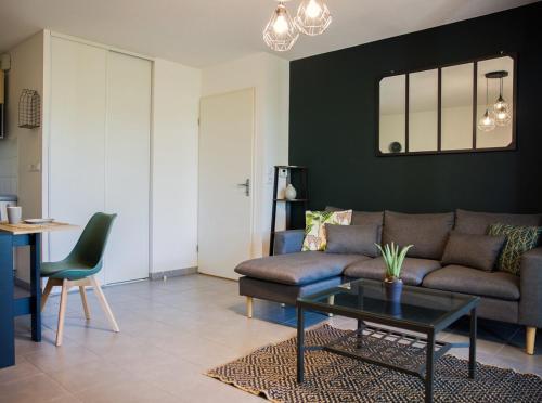 a living room with a couch and a table at OIQIA • Séquoia in LʼUnion
