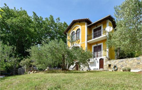 a yellow house with a tree in front of it at Cozy Home In Srinjine in Srinjine