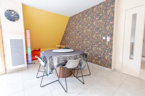 une table et des chaises dans une pièce avec un mur dans l'établissement L'écrin d'élégance, à Tours