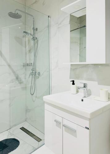 a white bathroom with a sink and a shower at SeeYou in St. Paul's Bay