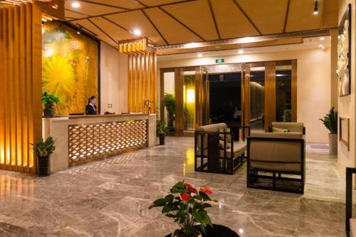 a lobby of a hotel with a person standing at a counter at Chambery Hotel in Zhuhai