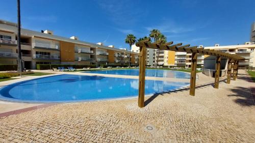 a swimming pool in front of a apartment building at Vilamoura TOP MouraPraia in Vilamoura