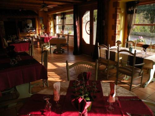 restauracja ze stołami i krzesłami z czerwoną tkaniną w obiekcie Retour Aux Sources w mieście Meyras