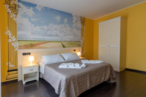 a bedroom with a bed with a painting on the wall at Hotel Oberdan Ristorante Pizzeria in Concordia Sagittaria