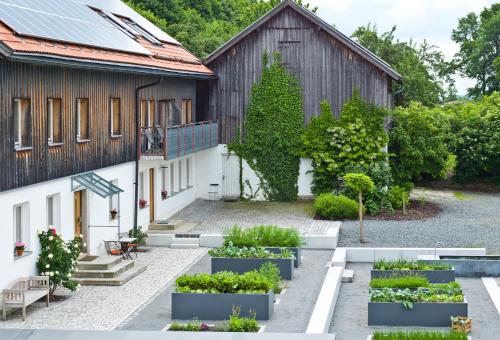 a garden in front of a building with plants at Biohotel Pausnhof in Sankt Oswald