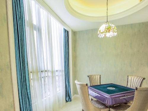 a dining room with a table and chairs and a chandelier at Vienna Hotel Guiyang Jiaxiulou Jichang Road in Guiyang