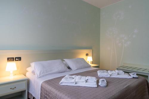 a bedroom with a bed with towels on it at Hotel Oberdan Ristorante Pizzeria in Concordia Sagittaria