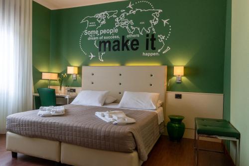 a bedroom with a large bed with a green wall at Hotel Oberdan Ristorante Pizzeria in Concordia Sagittaria