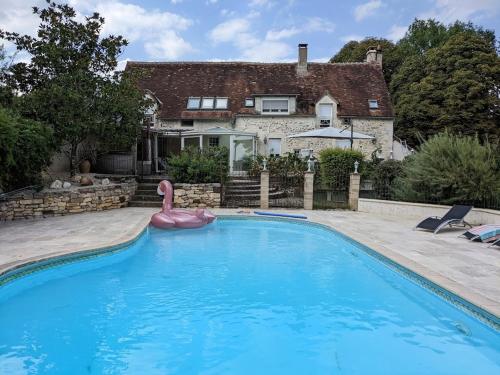 une piscine avec un flamingo rose en face d'une maison dans l'établissement La Guirtelle 12ou14 pers piscine, à Lainsecq