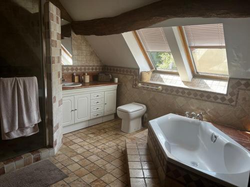 une salle de bain avec une baignoire, des toilettes et un lavabo dans l'établissement La Guirtelle 12ou14 pers piscine, à Lainsecq