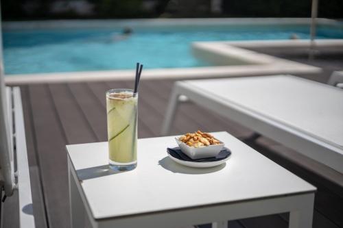 a drink on a table next to a bowl of food at Evora Olive Hotel in Évora