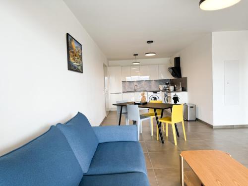 un salon avec un canapé bleu et une table dans l'établissement BEL' ORIZONTE proche centre ville et plage, à Propriano