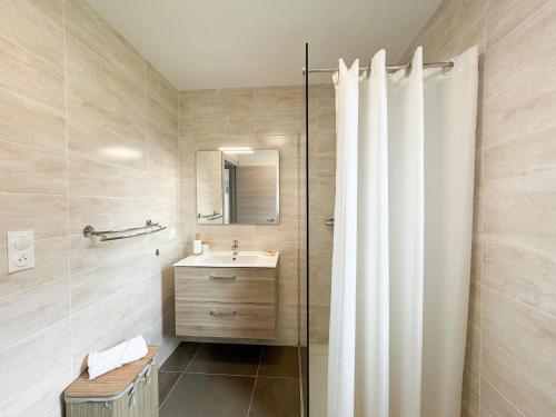 une salle de bain avec un rideau de douche et un lavabo dans l'établissement BEL' ORIZONTE proche centre ville et plage, à Propriano