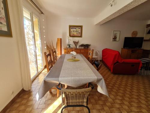 une salle à manger avec une table et des chaises dans une pièce dans l'établissement La maison ensoleillée, à Rivesaltes
