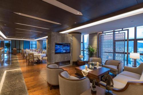 a hotel lobby with tables and chairs and a television at Dali Hotel in Dali