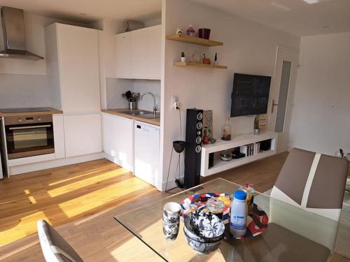 un salon avec une table en verre et une cuisine dans l'établissement Grand appartement lumineux Rennes, à Rennes