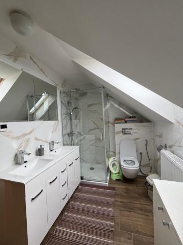 a bathroom with two sinks a toilet and a shower at Chata Nikol in Oravská Lesná