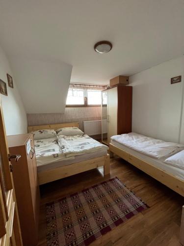 a room with two beds and a rug at Chata Nikol in Oravská Lesná