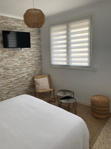 - une chambre avec un lit, une télévision et des chaises dans l'établissement T1 Sélizia, à Canet