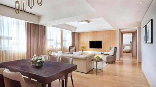 a living room with a couch and a table in a room at Shama Daqing Heilongjiang in Daqing