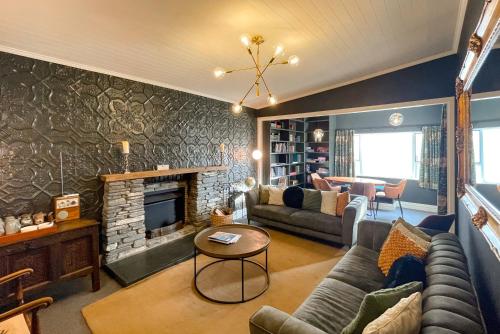 a living room with a couch and a fireplace at Kinloch Wilderness Retreat in Glenorchy