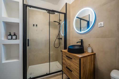 une salle de bain avec une douche avec un lavabo et un miroir dans l'établissement OIQIA • Impérium, à Narbonne