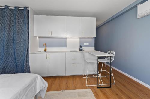 - une cuisine blanche avec un évier et un bureau dans l'établissement M41 Studio lumineux avec vue sur Montagne, à Annemasse