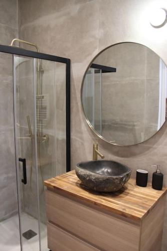 une salle de bain avec un lavabo noir et un miroir dans l'établissement Le bambou - Appartement avec terrasse, à Marseille