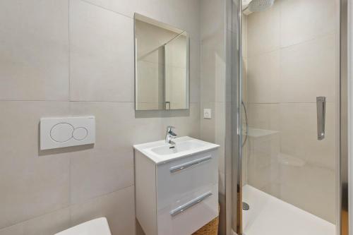 une salle de bain blanche avec un lavabo et un miroir dans l'établissement M41 Studio lumineux avec vue sur Montagne, à Annemasse