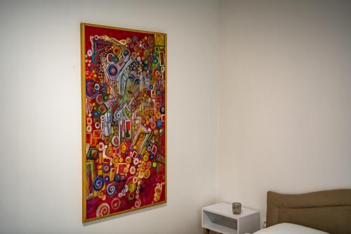 a painting hanging on a wall next to a bed at Nature View in Mostar