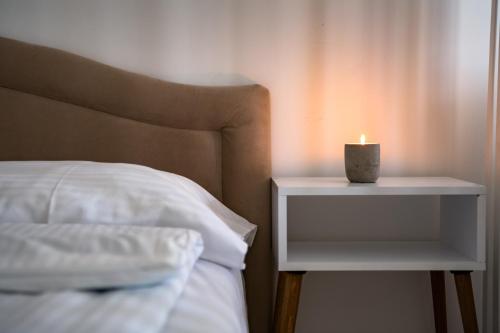 a candle on a night stand next to a bed at Nature View in Mostar
