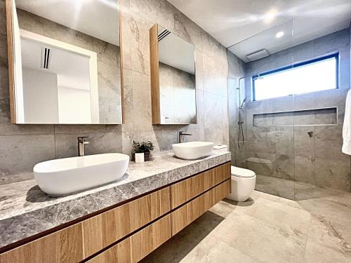 a bathroom with two sinks and a toilet at Elegant 4 Bedrooms Sanctuary in Bentleigh East in Carnegie