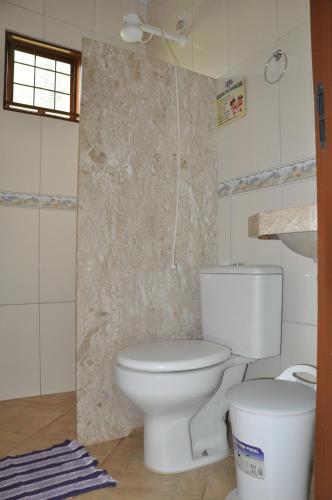 a bathroom with a white toilet in a room at Recanto Vovô Octávio - Refúgio Encantador em meio a Natureza in Olímpia