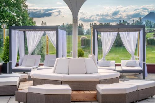 a patio with white chairs and a gazebo at Vitalhotel Sonnenhof in Going