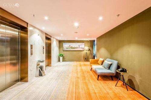 a living room with a couch and a chair at AURAYA BY SUNING NANJING XUZHUANG in Nanjing